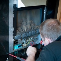 a heating contractor servicing a gas fireplace